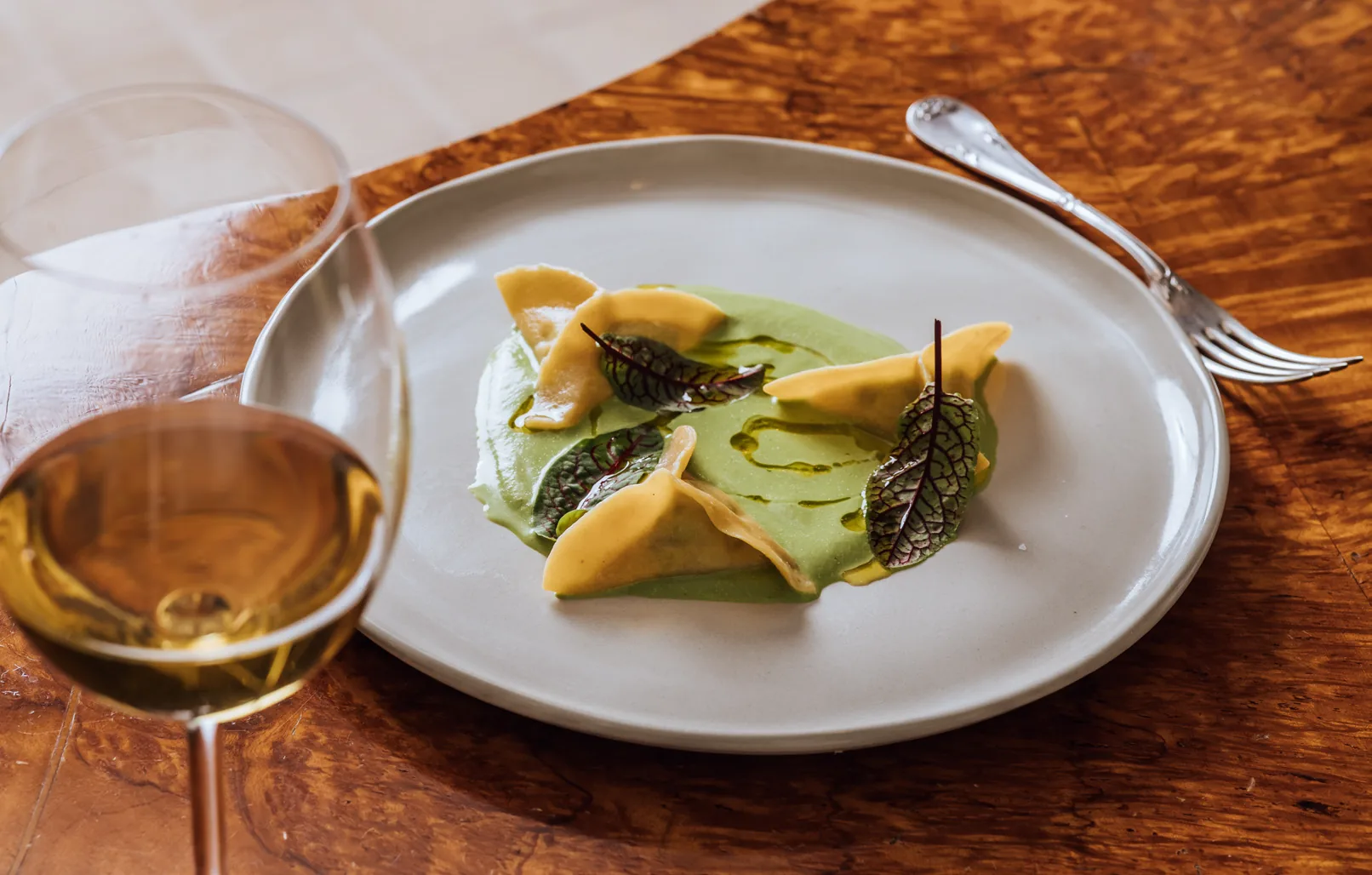 Ravioli recheado de costela, creme de ervilhas e azedinha